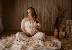 Mother-to-be sitting gracefully in a bohemian styled dress