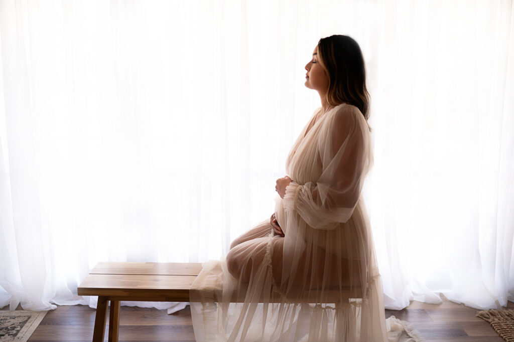 Maternity image of a client sitting in a flowing dress, by Fort Worth Photographer Paula Goforth 