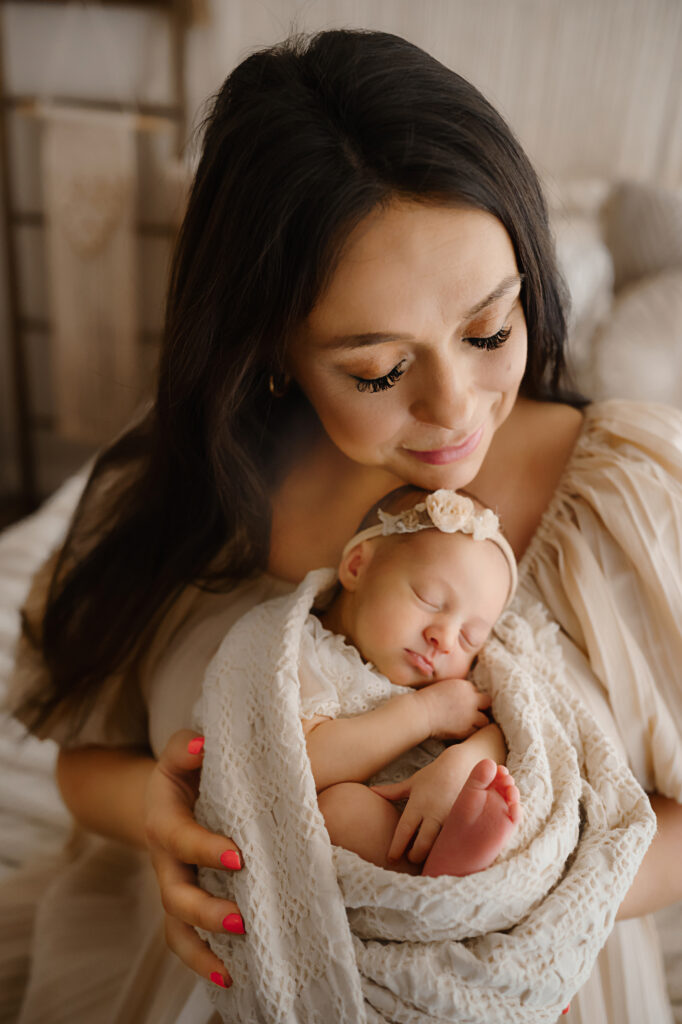 Swaddled newborn in adorable bohemian styling with it's mother. Image by Fort Worth photographer Paula Goforth