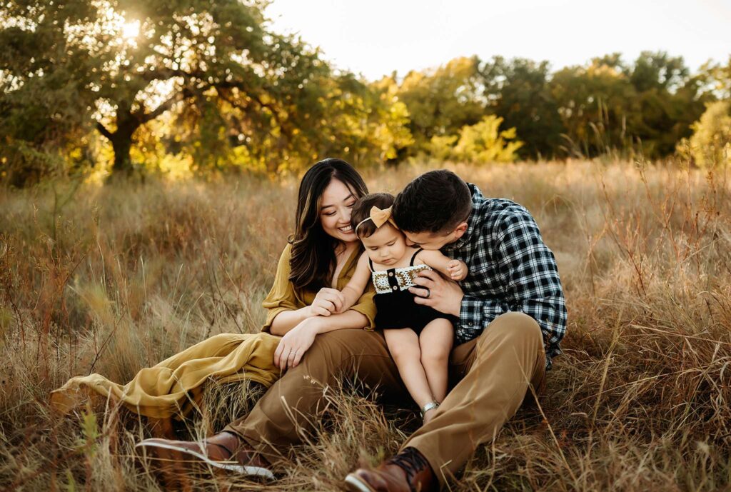 Golden light in a family photo of a mom, dad, and baby by Fort Worth Photographer Paula Goforth 