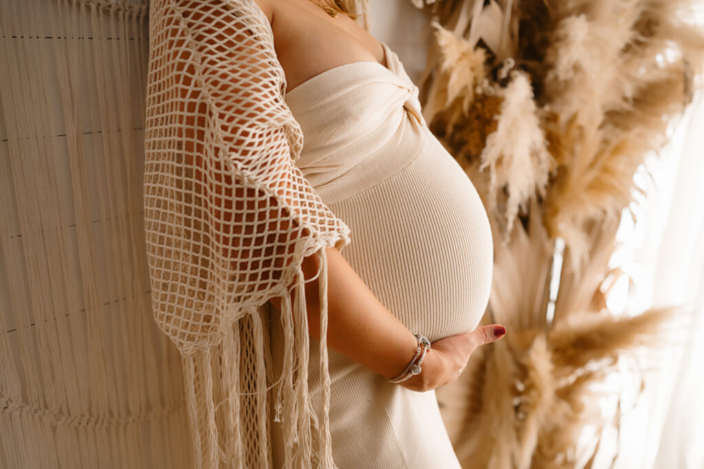 Fort Worth maternity photo from Paula Goforth, featuring an expectant mom and beautiful cream and beige tones of fabric.