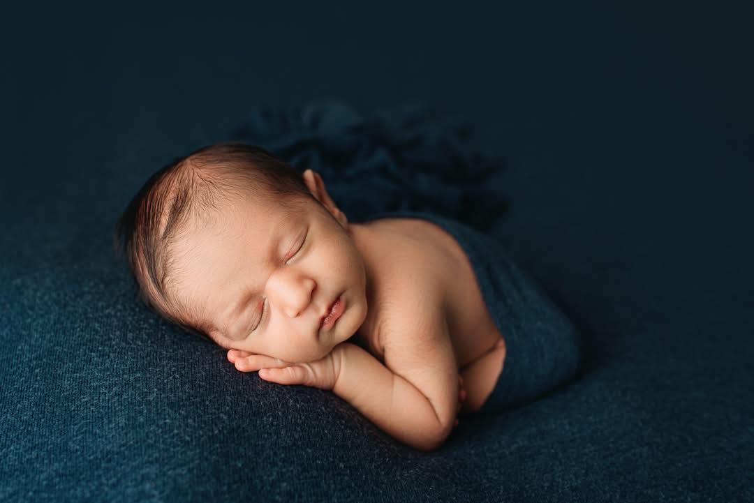 Swaddled newborn in teal wrap. Image by Fort Worth Photographer Paula Goforth