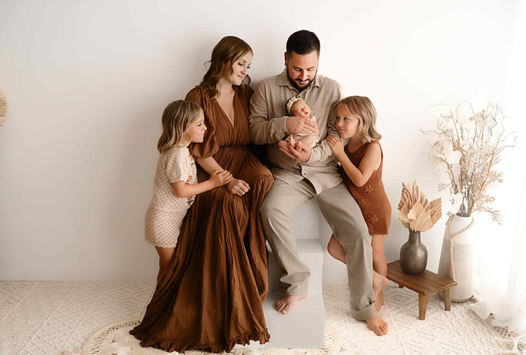 Natural, soft newborn portraits captured during the postpartum season, featuring warm tones, gentle posing, and heartfelt moments between mother and baby.