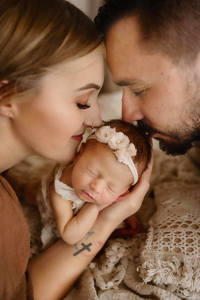 Natural, soft newborn portraits captured during the postpartum season, featuring warm tones, gentle posing, and heartfelt moments between mother and baby.