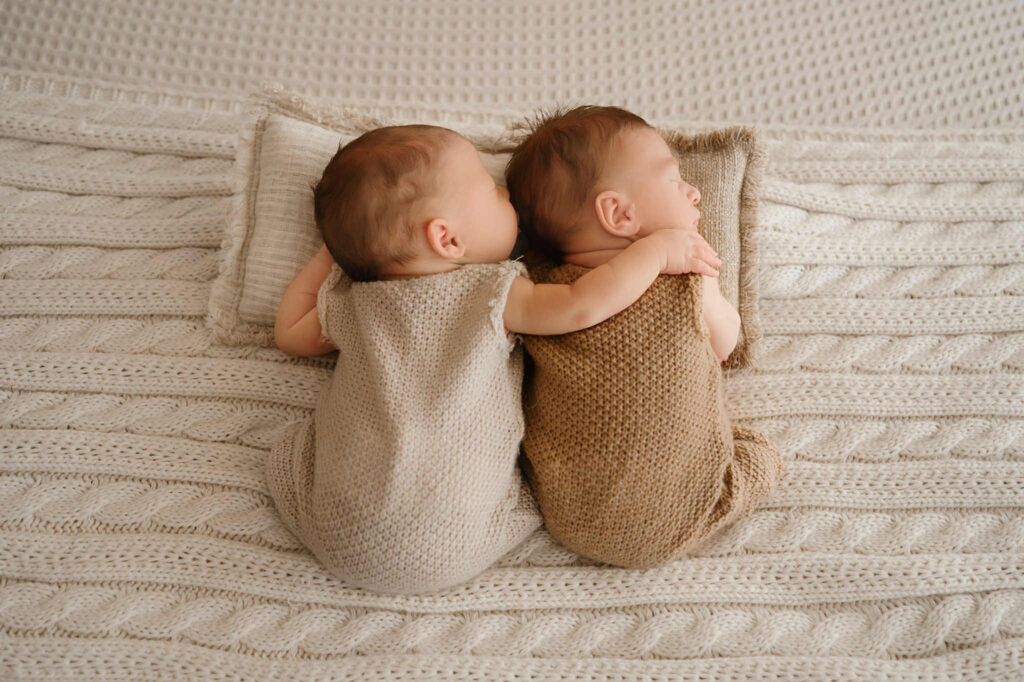 Newborn twin brothers peacefully sleeping side by side in a Fort Worth photography studio