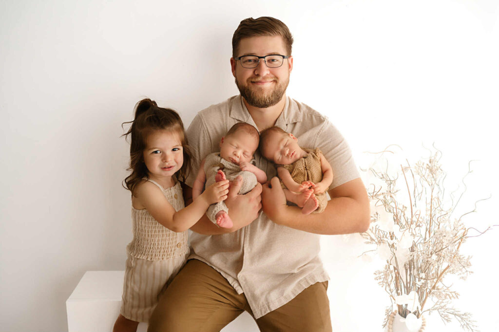 Lifestyle newborn photo of twin brothers with soft baby blue and beige airplane nursery theme in Fort Worth
